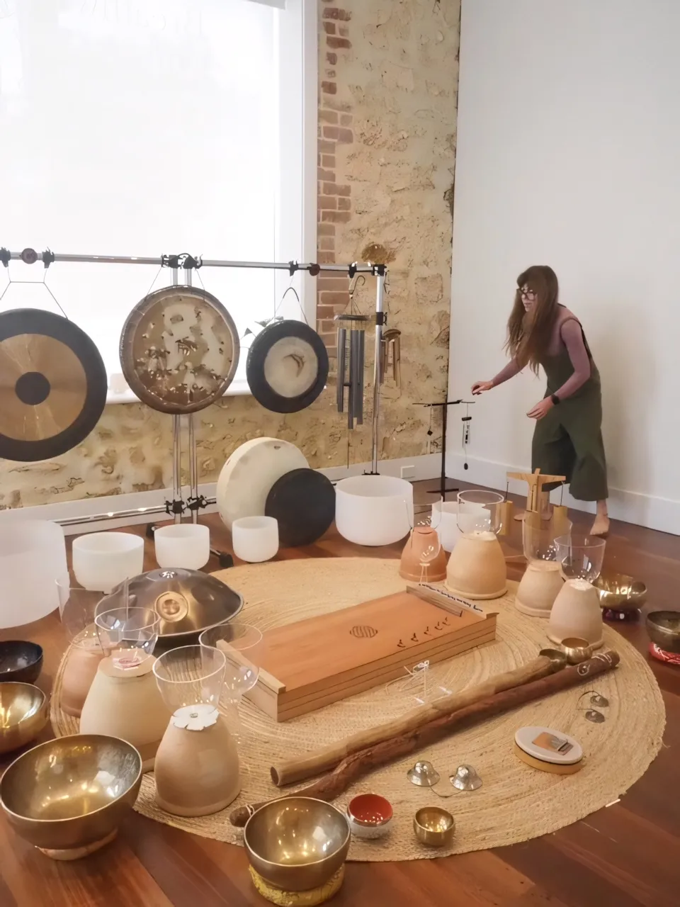 Danielle preparing gongs, bowls and other resonant instruments in her studio.