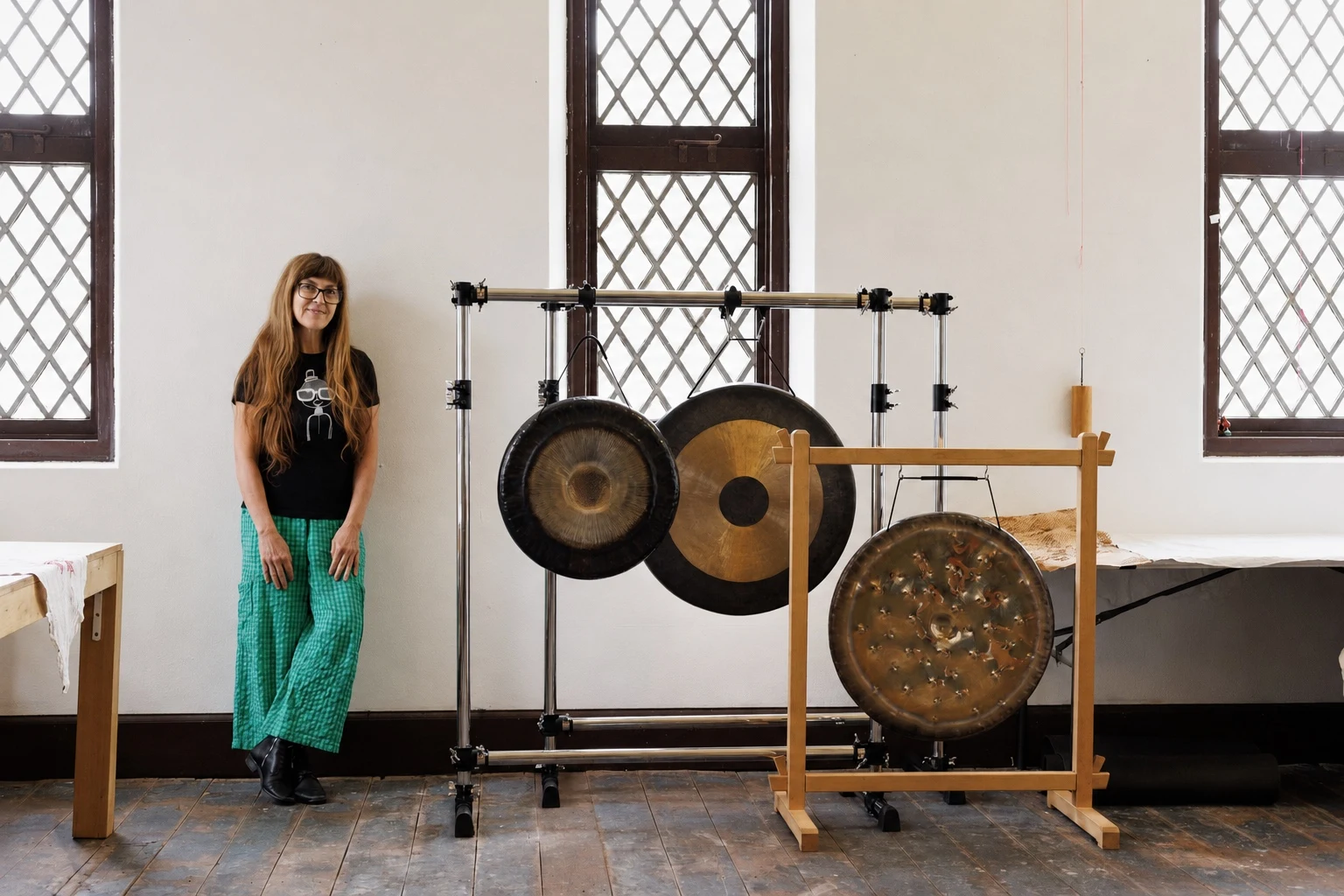 Danielle standing beside a collection of suspended gongs.