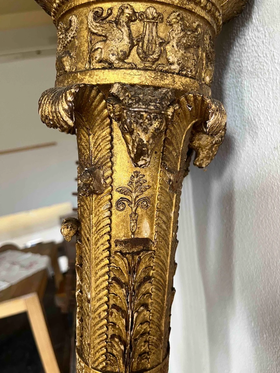 Close view of worn gilded carving and ornament on the Érard harp’s column.
