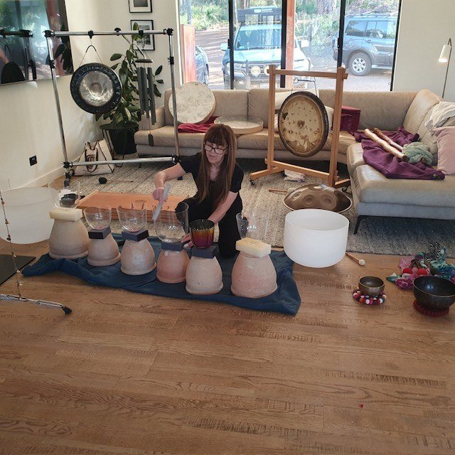 Danielle sits behind an arrangement of crystal bowls and chalices during a retreat.